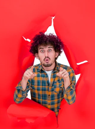 young-male-with-curly-hair-yellow-ripped-background